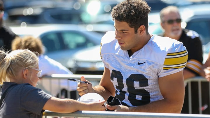 Iowa linebacker Jayden Montgomery signs an autograph before practice on Aug. 10, 2024 in Iowa City. (Rob Howe/HN)  