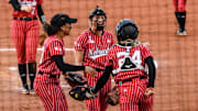 Samantha Bland (left), Jordy Bahl (middle) and Ava Bredwell (24) celebrate Bredwell's diving catch in the infield. 