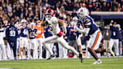 Ty Simpson (15) runs with the ball against Auburn