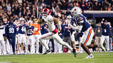 Ty Simpson (15) runs with the ball against Auburn