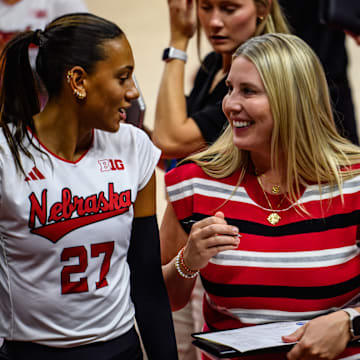 Harper Murray (left) and Dani Busboom Kelly chat before the start of the second set. 