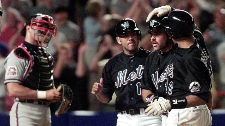 New York Mets catcher Mike Piazza holds the ball as he rolls over