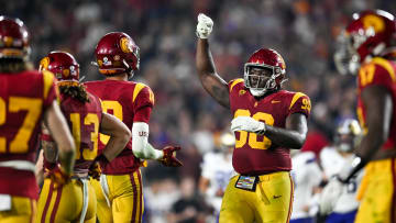 Nov 4, 2023; Los Angeles, California, USA; USC Trojans defensive lineman Bear Alexander (90) celebrates with linebacker Eric Gentry (18) and other teammates against the Washington Huskies during the fourth quarter at United Airlines Field at Los Angeles Memorial Coliseum. Mandatory Credit: Jonathan Hui-USA TODAY Sports
