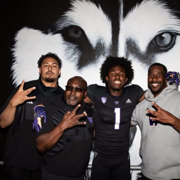 Wide receiver Deji Ajose takes a photo with his host coaches. 