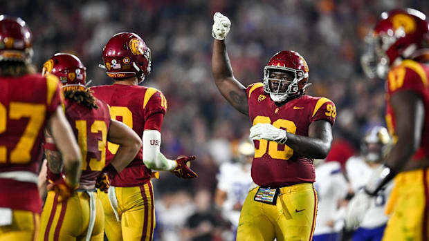 Trojans defensive lineman Bear Alexander (90) celebrates with linebacker Eric Gentry (18)