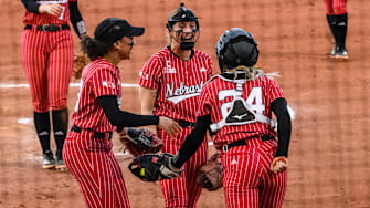 Samantha Bland (left), Jordy Bahl (middle) and Ava Bredwell (24) celebrate Bredwell's diving catch in the infield. 