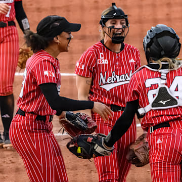 Samantha Bland (left), Jordy Bahl (middle) and Ava Bredwell (24) celebrate Bredwell's diving catch in the infield. 