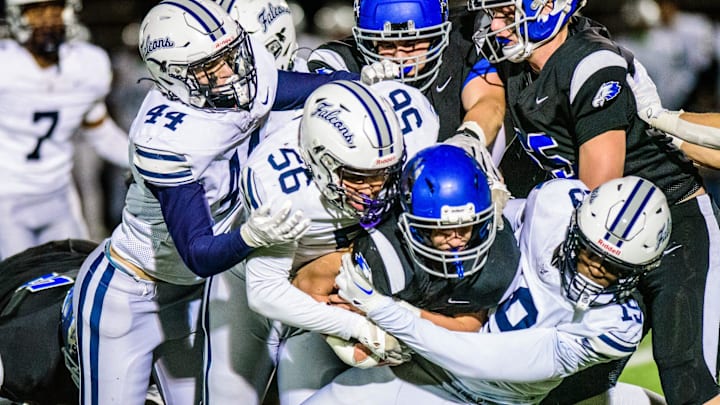 Farmington's Carter Kulinski, Jordan Fernandez and Myles Smith wrap up White Lake Lakeland's Sam Broome during the Division 2 football district semifinal on Friday, Nov. 1, 2024.