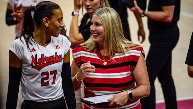 Harper Murray (left) and Dani Busboom Kelly chat before the start of the second set. 