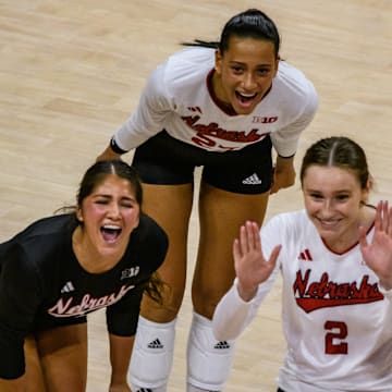 Lexi Rodriguez (left), Harper Murray (middle) and Bergan Reilly celebrate a kill from Rebekah Allick.  