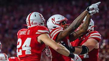 Isaiah Neyor (middle) celebrates after scoring a touchdown.