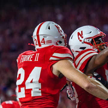 Isaiah Neyor (middle) celebrates in the endzone after scoring Nebraska's first touchdown of the game.