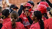 Ava Kuszak celebrates her home run with teammates at home plate. 