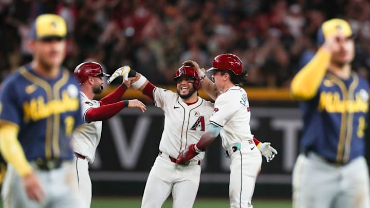 Arizona Diamondbacks third base Eugenio Suarez (28) is mobbed by Arizona Diamondbacks first base Christian Walker (53) and Arizona Diamondbacks outfielder Corbin Carroll (7) after his walk-off hit on Sept. 15, 2024 at Chase Field in Phoenix.