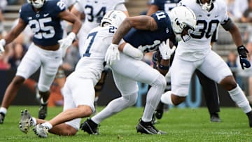 Penn State safety Lamont Payne Jr. (27) tackles wide receiver Kyron Hudson (11) during the Blue-White game at Beaver Stadium