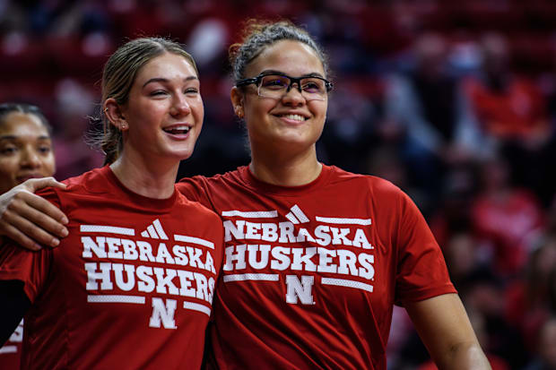Rebekah Allick (right) puts her arm around Andi Jackson (left) during pre-game warmups. 
