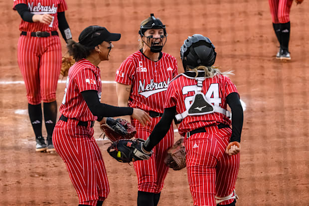 Samantha Bland (left), Jordy Bahl (middle) and Ava Bredwell (24) celebrate Bredwell's diving catch in the infield. 