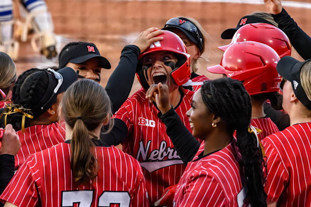 Ava Kuszak celebrates her home run with teammates at home plate. 