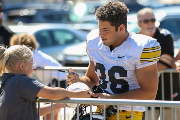 Iowa linebacker Jayden Montgomery signs an autograph before practice on Aug. 10, 2024 in Iowa City. (Rob Howe/HN)  