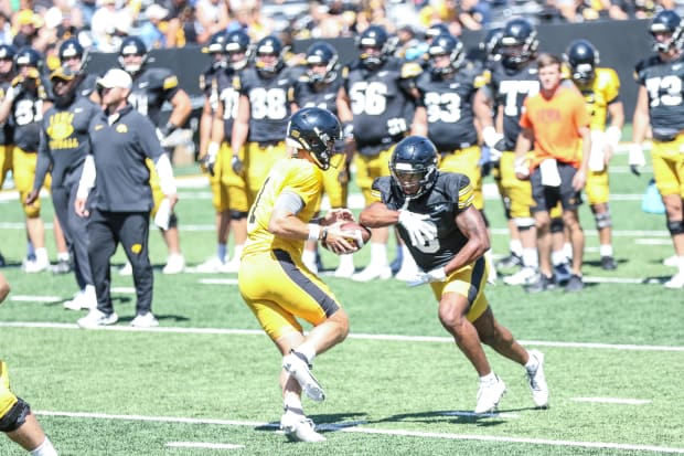 Iowa QB Brendan Sullivan fakes a handoff to RB Terrell Washington Jr. at practice on Aug. 10, 2024 in Iowa City. (Rob Howe/HN