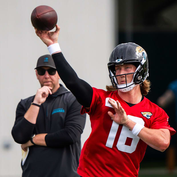 Jacksonville Jaguars quarterback Trevor Lawrence (16) passes as Jacksonville Jaguars head coach Liam Coen watches during the 