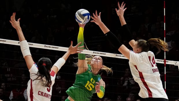 Wisconsin middle blocker Caroline Crawford (9) and opposite Anna Smrek (14) attempt to block the hit from Oregon outside hitt