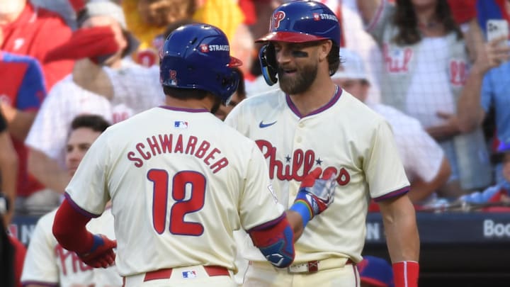 Philadelphia Phillies designated hitter Kyle Schwarber (12) celebrates with Philadelphia Phillies first baseman Bryce Harper (3) after a solo home run against the New York Mets in the first inning in game one of the NLDS for the 2024 MLB Playoffs at Citizens Bank Park.