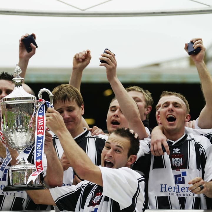 Brigg Town captain Phil Rowland lifts the trophy up