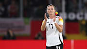 Alexandra Popp mit der Deutschland-Binde in der Hand