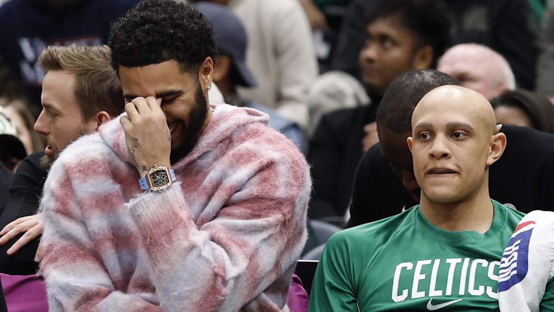 Dec 4, 2025; Washington, District of Columbia, USA; Injured Boston Celtics forward Jayson Tatum (L) reacts on the bench against the Washington Wizards in the second half at Capital One Arena.