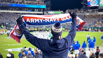 A Navy fan urges on the Midshipmen as the Army-Navy game goes to overtime for the first time in the