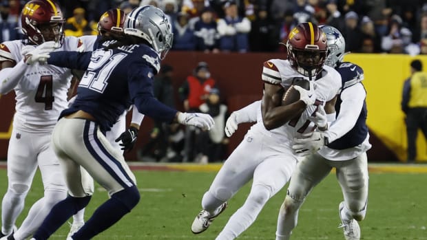 Terry McLaurin (17) runs with the ball as Dallas Cowboys safety Donovan Wilson (6) chases 