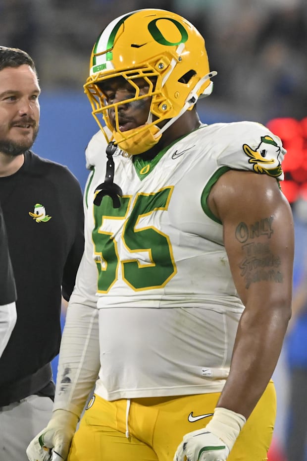 Oregon Ducks head coach Dan Lanning talks to Oregon Ducks defensive lineman Derrick Harmon