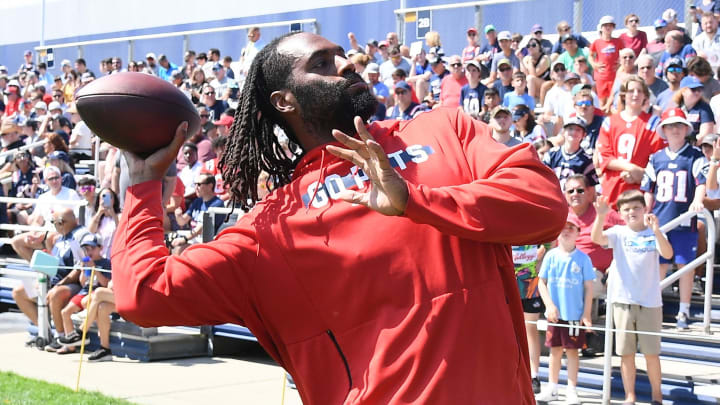 Jul 26, 2024; Foxborough, MA, USA; New England Patriots linebacker Matthew Judon (9) tosses a ball to fans during training camp at Gillette Stadium.