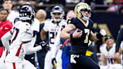 Jan 7, 2024; New Orleans, Louisiana, USA;  New Orleans Saints quarterback Taysom Hill (7) is chased out of bounds by Atlanta Falcons safety Richie Grant (27) during the second half at Caesars Superdome. Mandatory Credit: Stephen Lew-Imagn Images