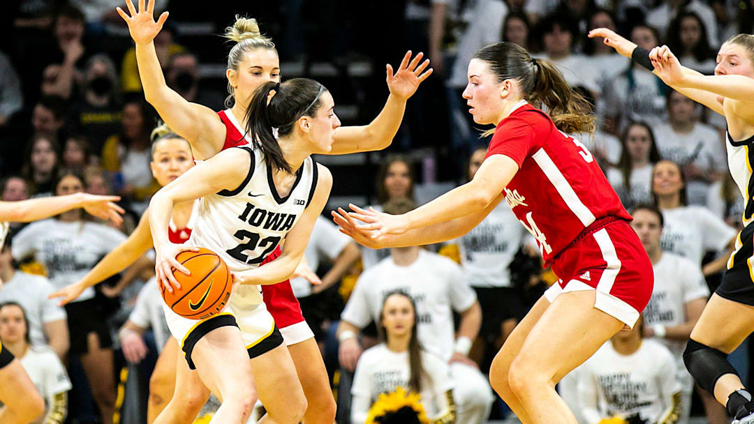 Iowa guard Caitlin Clark (22) is defended by Nebraska guard Jaz Shelley, left, and Nebraska forward Isabelle Bourne during the 2022-23 season.