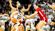 Iowa guard Caitlin Clark (22) is defended by Nebraska guard Jaz Shelley, left, and Nebraska forward Isabelle Bourne during the 2022-23 season.