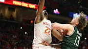 Nov 4, 2024; College Park, Maryland, USA; Maryland Terrapins center Derik Queen (25) dunks over Manhattan Jaspers forward Fraser Roxburgh (13) during the second half at Xfinity Center. Mandatory Credit: Daniel Kucin Jr.-Imagn Images