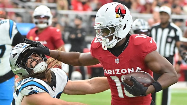 Sep 14, 2025; Glendale, Arizona, USA;  Arizona Cardinals wide receiver Marvin Harrison Jr. (18) runs the ball defended by Carolina Panthers linebacker Christian Rozeboom (56) during the third quarter at State Farm Stadium. Mandatory Credit: Matt Kartozian-Imagn Images