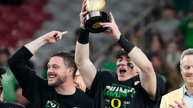 Oregon Ducks quarterback Bo Nix and head coach Dan Lanning celebrate after defeating the Liberty Flames to win the Fiesta Bow