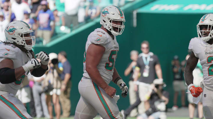 Miami Dolphins running back Chase Edmonds (2) celebrates scoring a touchdown with teammates lineman Connor Williams, center, and Robert Hunt, left, during the fourth quarter of an NFL game at Hard Rock Stadium in Miami Gardens, Sept. 25, 2022.