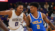 Dec 3, 2025; Seattle, Washington, USA; UCLA Bruins guard Donovan Dent (2) dribbles the ball while guarded by Washington Huskies guard Quimari Peterson (0) during the second half at Alaska Airlines Arena at Hec Edmundson Pavilion. Mandatory Credit: Steven Bisig-Imagn Images