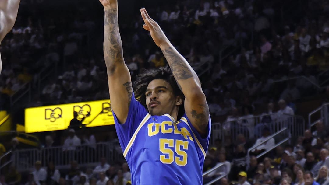 Feb 14, 2026; Ann Arbor, Michigan, USA; UCLA Bruins guard Skyy Clark (55) shoots on Michigan Wolverines forward Morez Johnson Jr. (21) in the second half at Crisler Center. Mandatory Credit: Rick Osentoski-Imagn Images