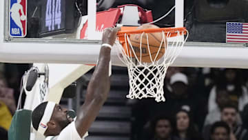 Oct 10, 2024; Milwaukee, Wisconsin, USA; Milwaukee Bucks forward Bobby Portis (9) dunks the ball against Los Angeles Lakers forward LeBron James (23) in the first half  at Fiserv Forum. Mandatory Credit: Michael McLoone-Imagn Images