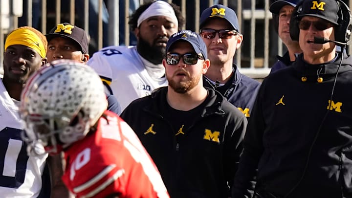 Nov 26, 2022; Columbus, Ohio, USA; Michigan Wolverines head coach Jim Harbaugh watches from the sideline beside off-field analyst Connor Stalions, right, during the NCAA football game against the Ohio State Buckeyes at Ohio Stadium.