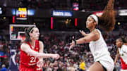 Indiana Fever guard Caitlin Clark passes around Chicago Sky forward Angel Reese.