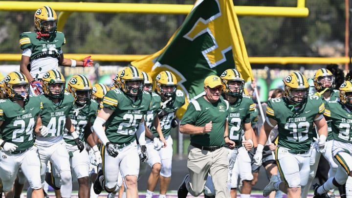 St. Edward takes the field before a football game in 2023, led by head coach Tom Lombardo. 