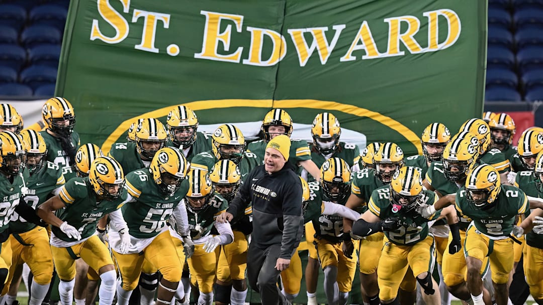 Head coach Tom Lombardo leads St. Edward onto the field prior to the 2022 OHSAA Division I state championship game at Tom Benson Hall of Fame Stadium in Canton, Ohio. 