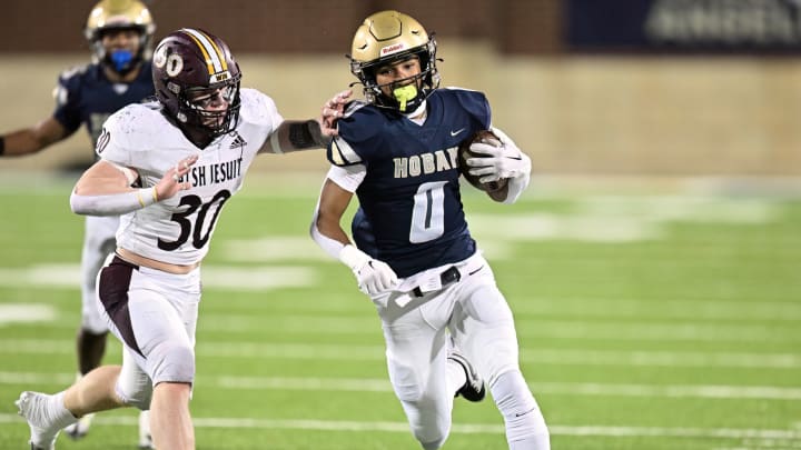 Archbishop Hoban wide receiver Payton Cook tries to run away from a Walsh Jesuit defender during the 2023 regional final.