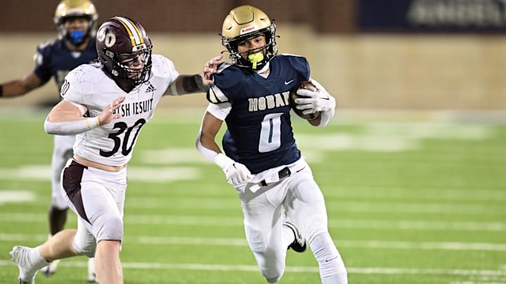 Archbishop Hoban wide receiver Payton Cook tries to run away from a Walsh Jesuit defender during the 2023 regional final.